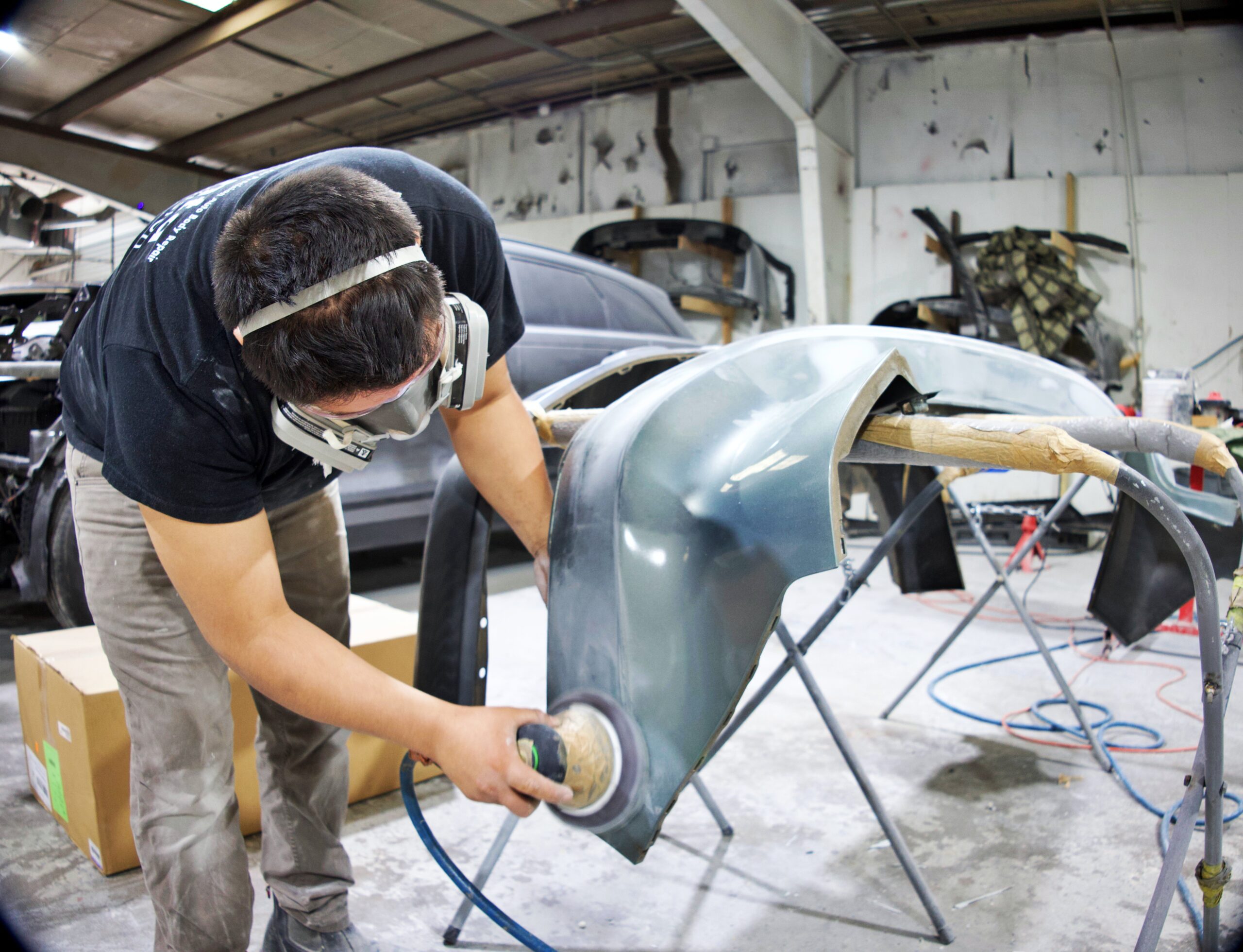 Worker Sanding Down Car Body Part | Atlanta Auto Collision