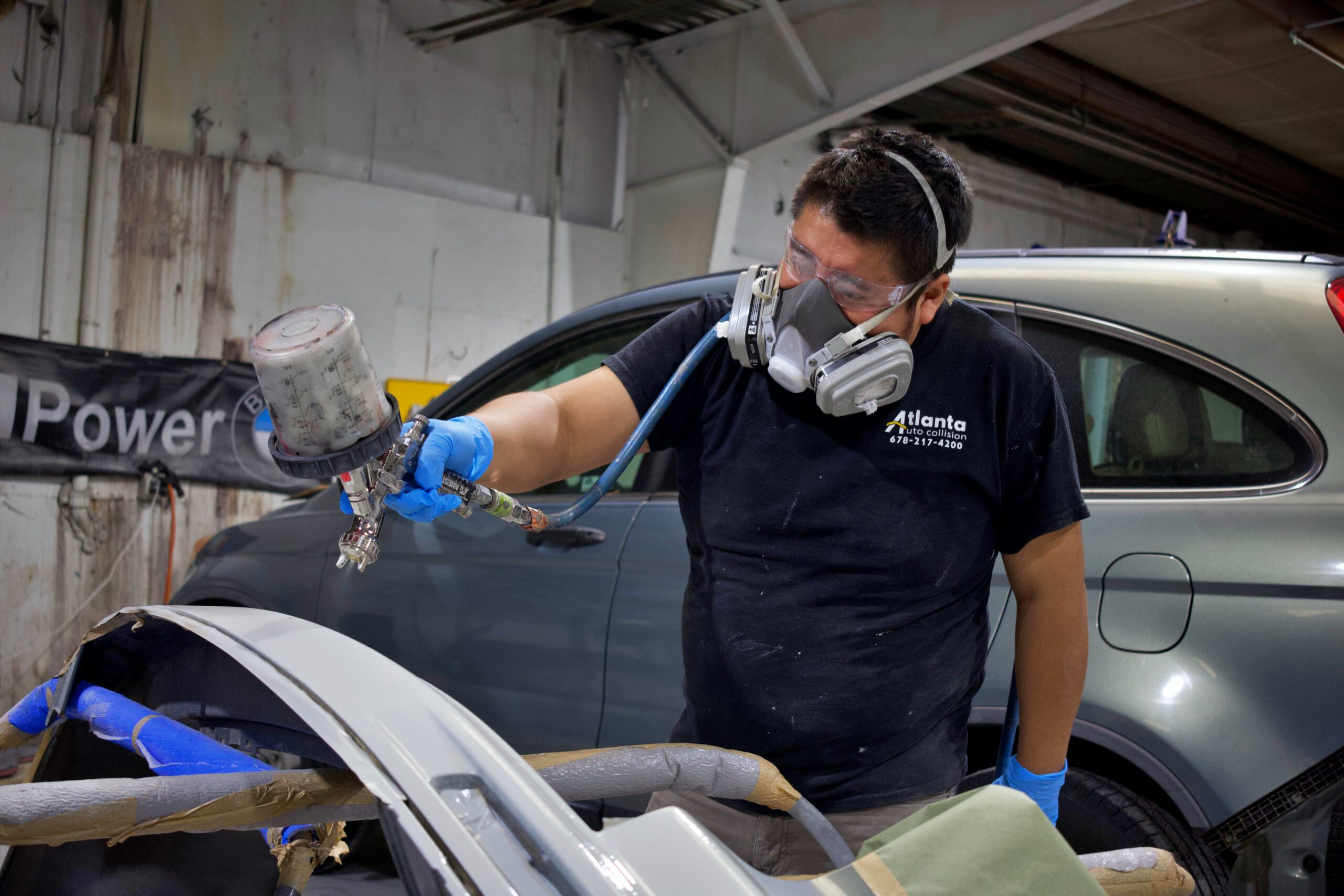 Worker Spray Painting Car Part | Atlanta Auto Collision